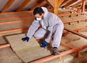 Man installing insulation in celling